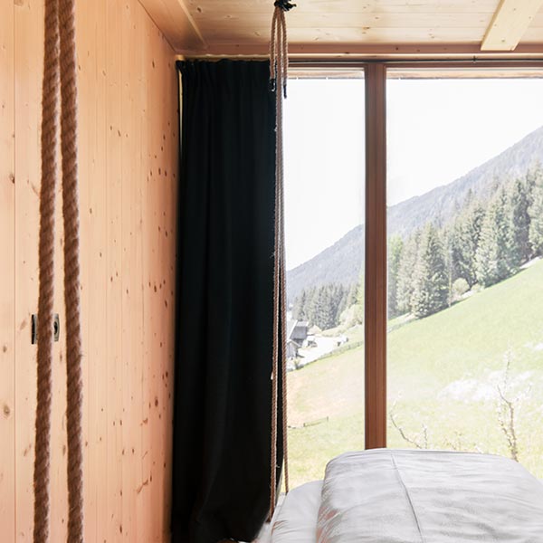 Einrichtung aus Holz mit Sicht auf eine grüne Naturlandschaft