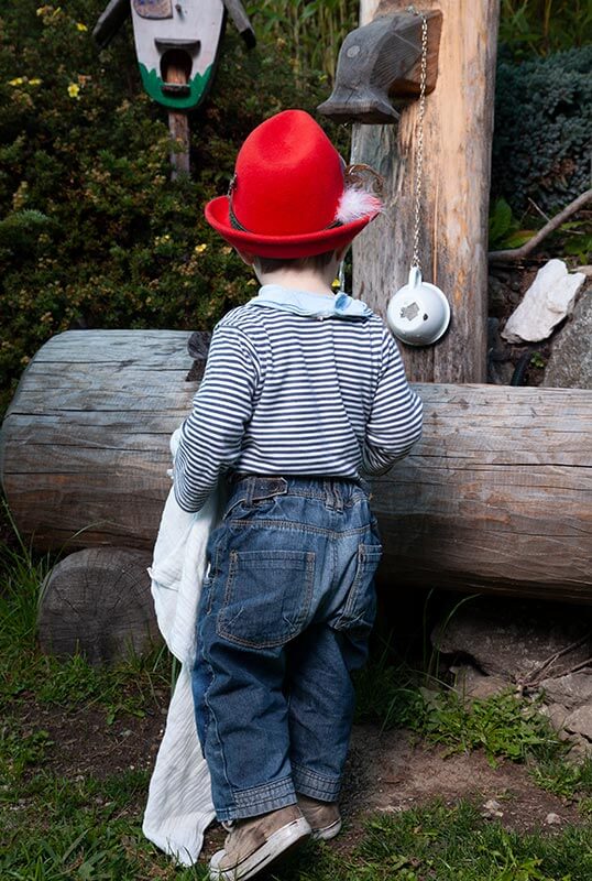 Bambino davanti a una fontana a Valle di Casies